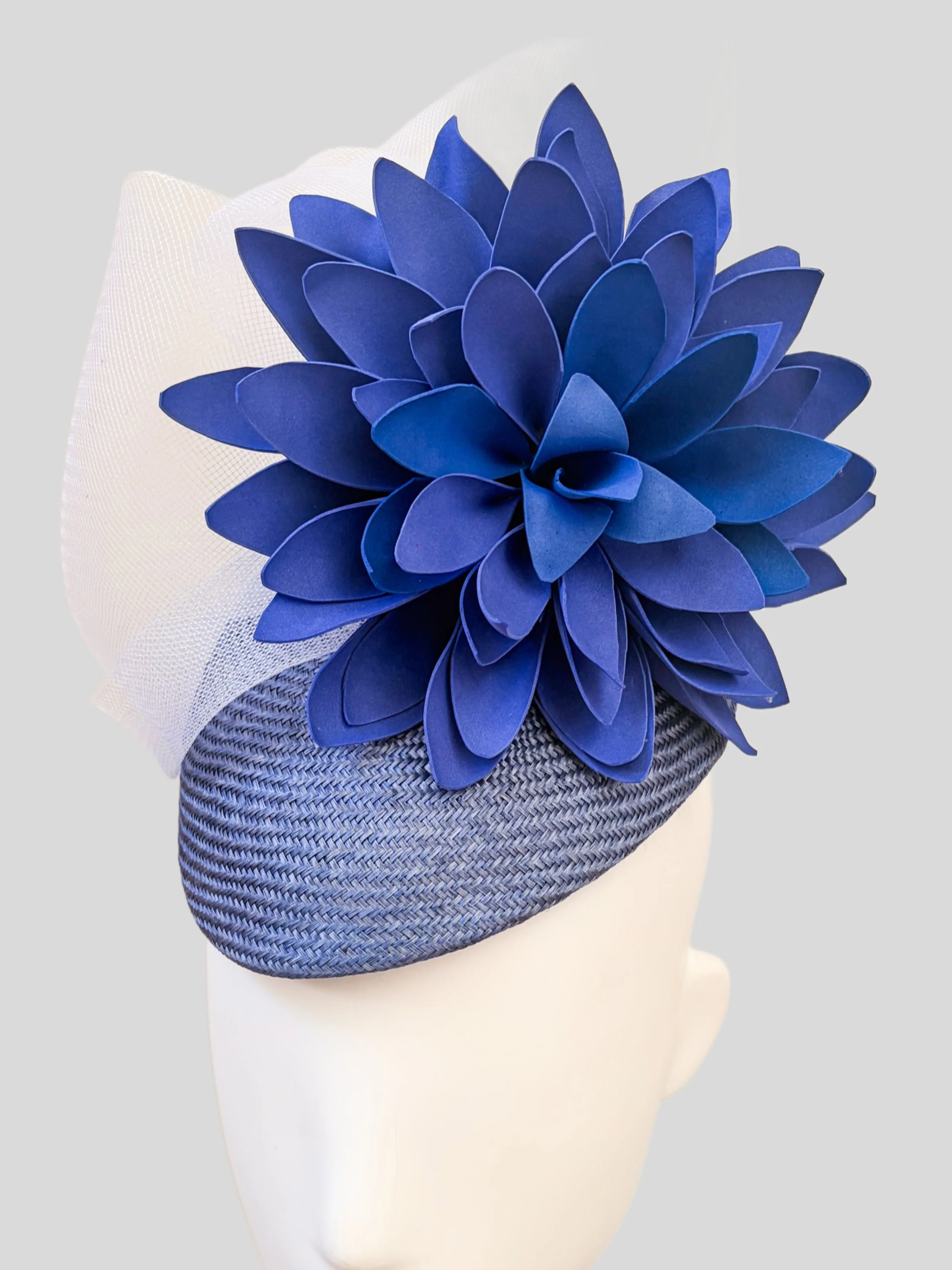 Close-up detail of the layered blue flower, Parisisal straw texture and delicate white crinoline.