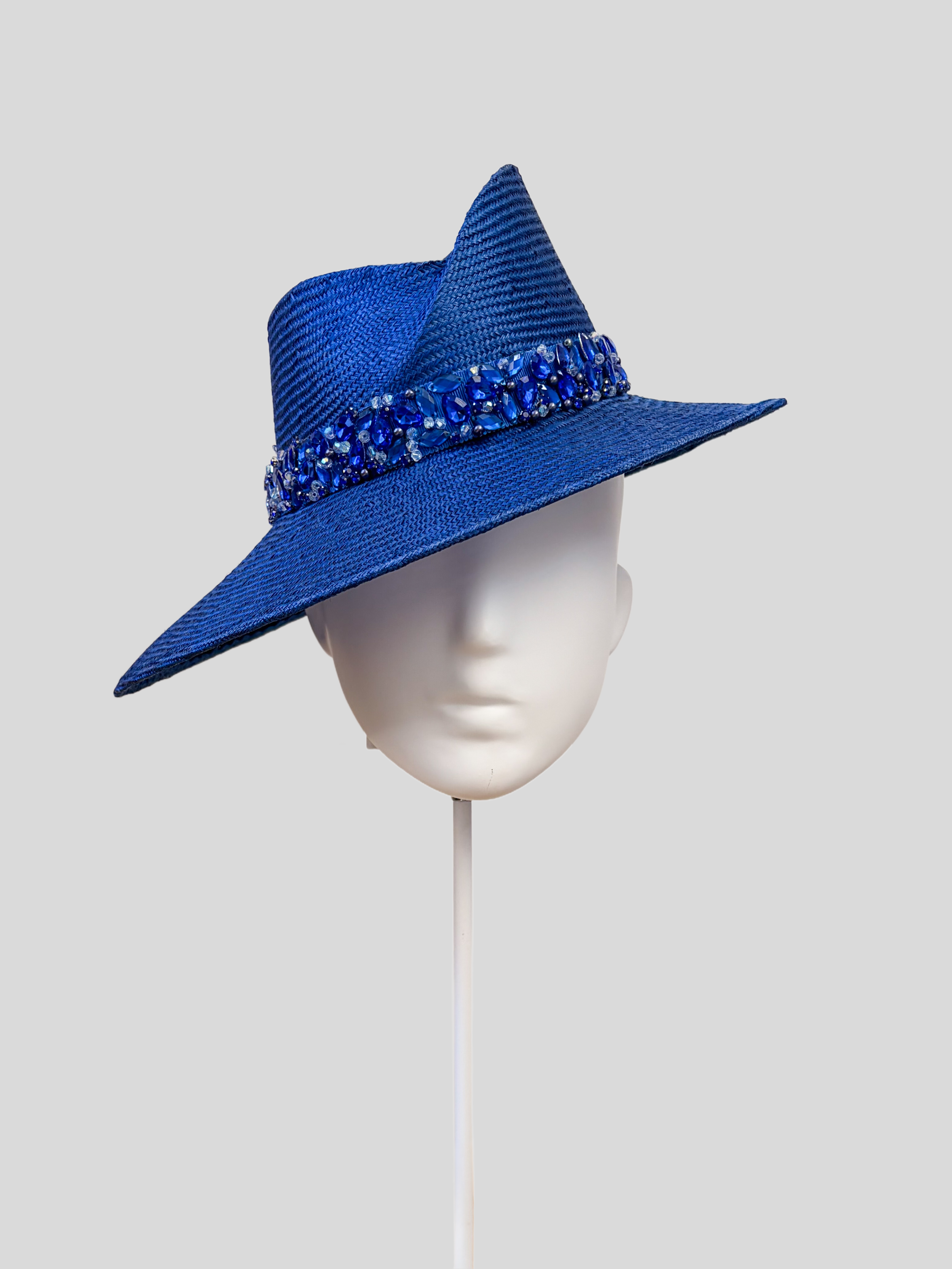 Front: MAISON Sapphire Parisisal fedora featuring a sculptural Divine Millinery block and hand-embellished blue beaded band.