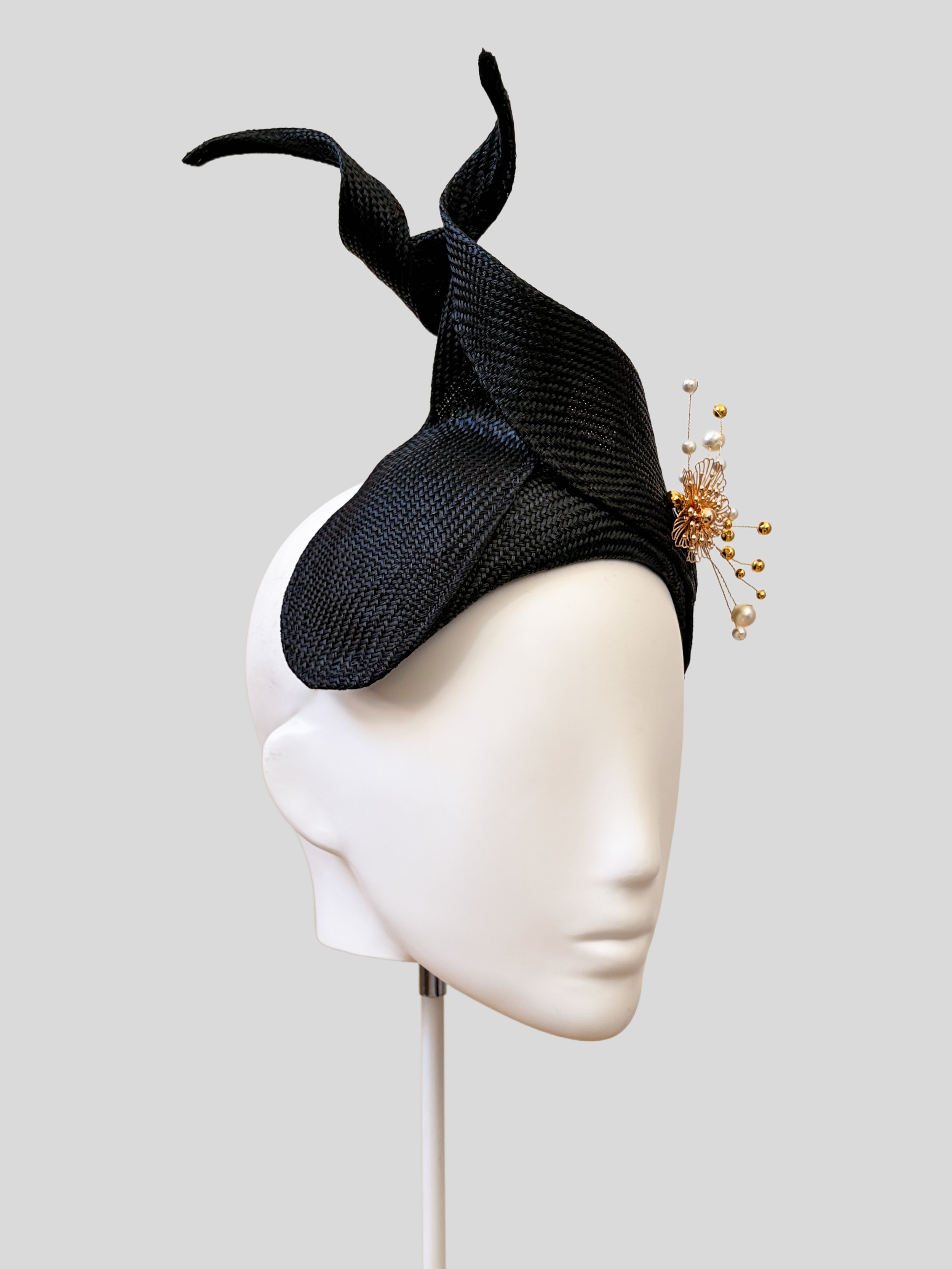 Left: Side view of the SÉLÈNE Noir Parisisal bandeau headband showcasing its twisted sculptural Parisisal detail.