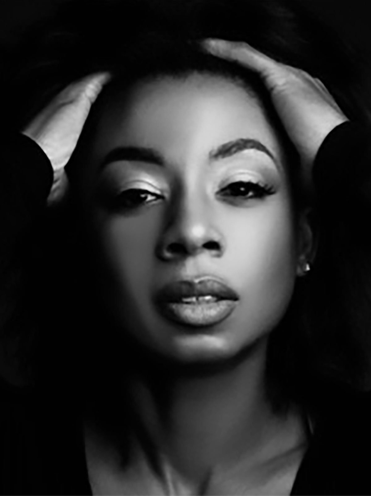 Woman in black and white running her fingers through her hair