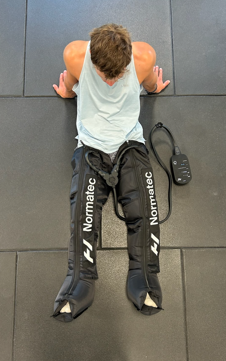 Person wearing Normatec 3 compression boots during a recovery session at home in Christchurch NZ