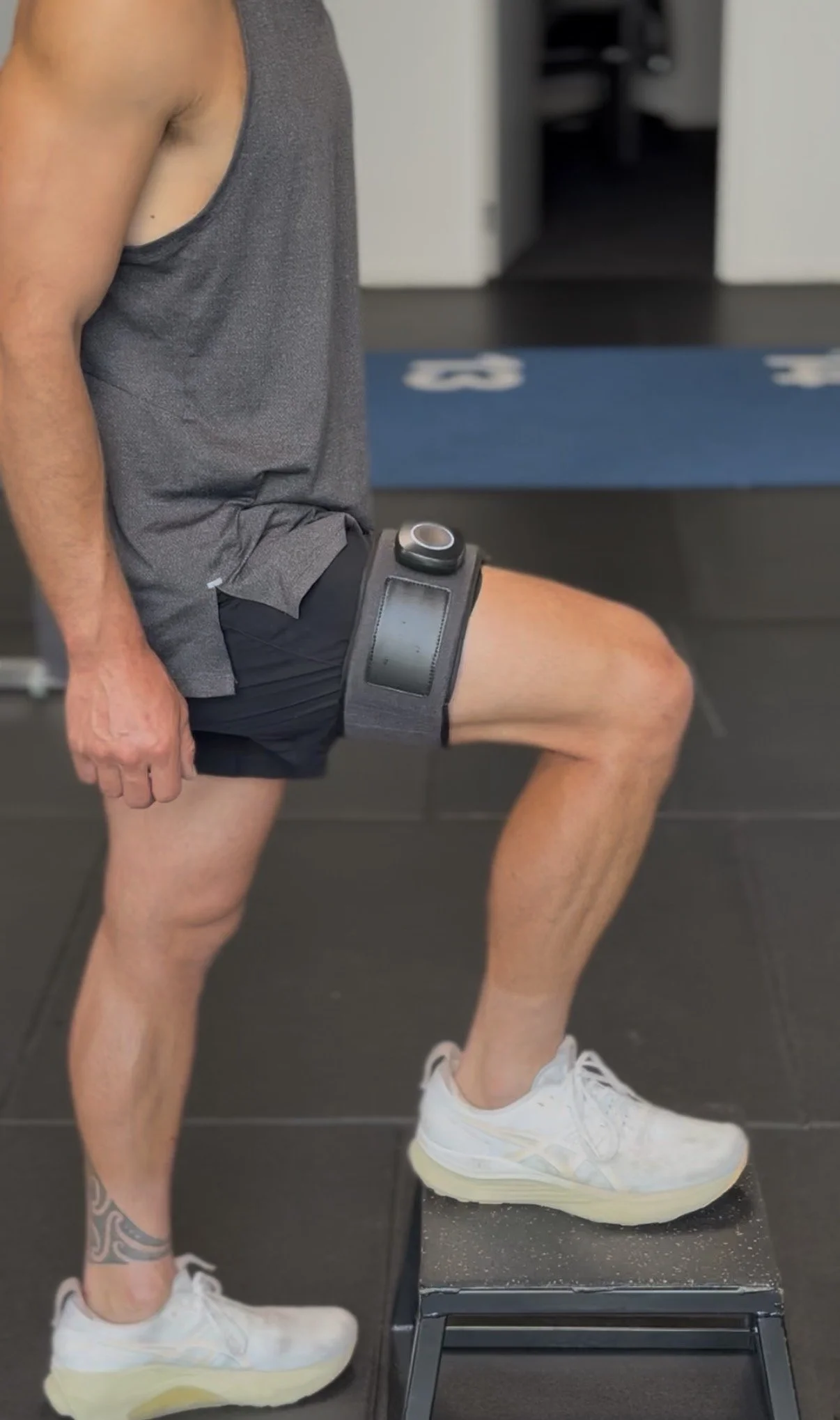 SAGA BFR cuffs worn on upper thigh during blood flow restriction training exercise for post-surgery rehabilitation