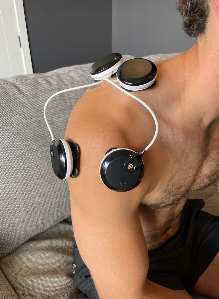 Compex muscle stimulator in use during post-surgical recovery — EMS therapy for muscle reactivation and strength rebuilding at home