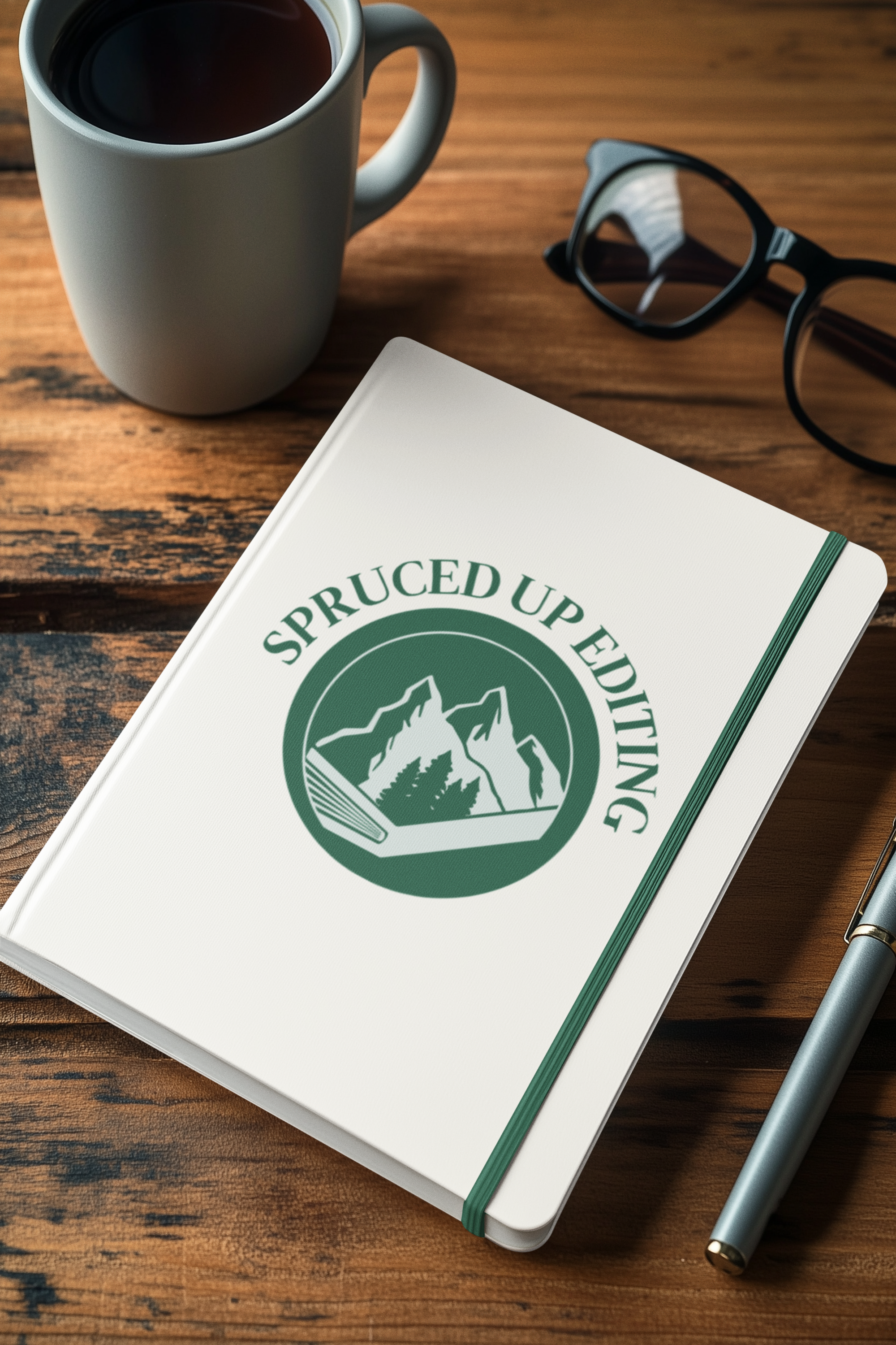 mockup-of-an-ai-generated-hardcover-journal-lying-on-a-table-with-a-pair-of-glasses-and-a-pen-m53854.png