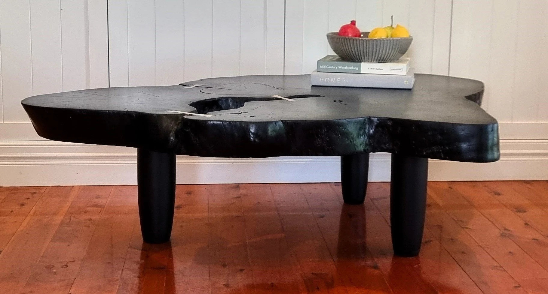 Currently available --
Large coffee table made of a burned live-edge mango slab, finished with brass bow-tie details.