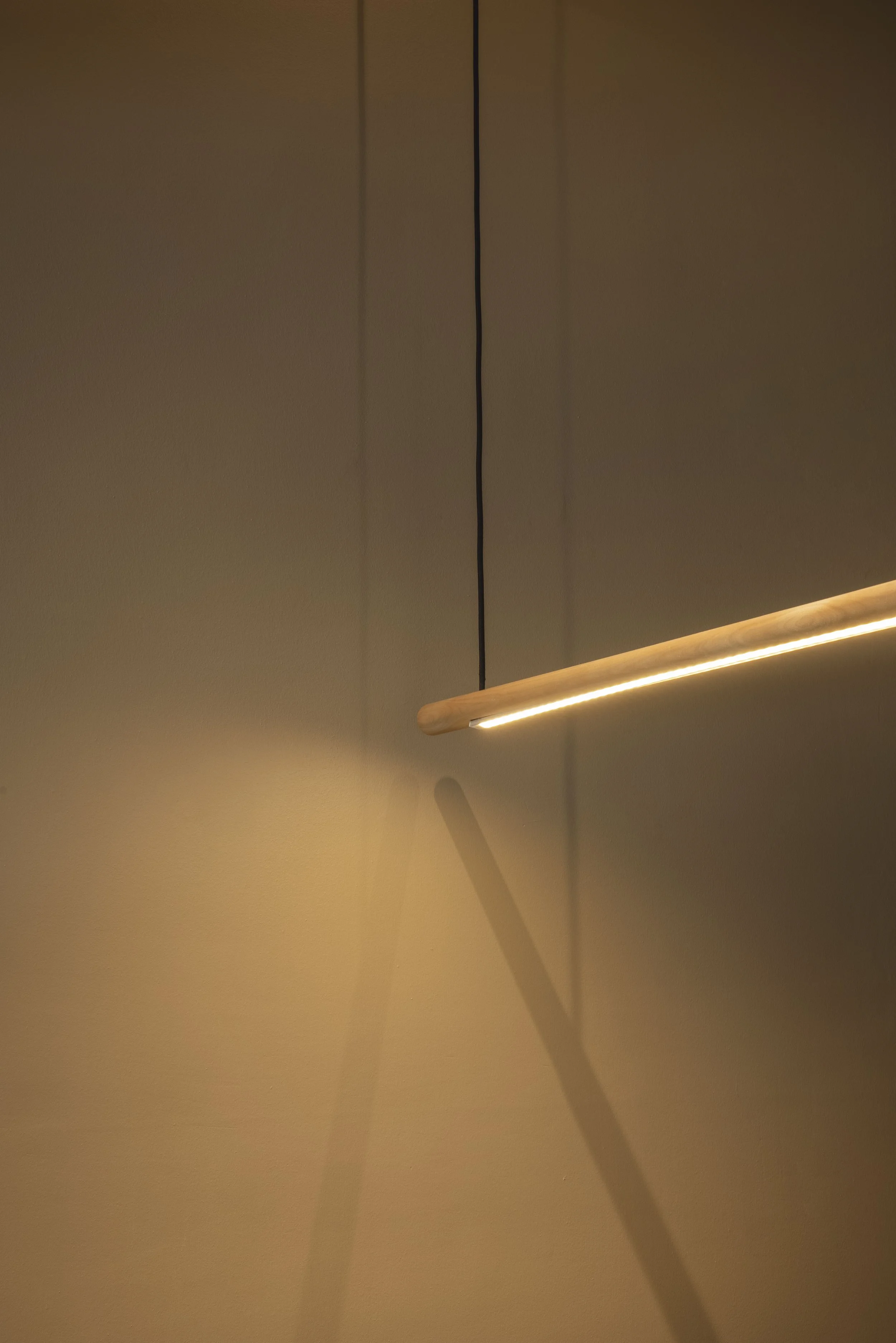 Warm linear wall light illuminating a textured brown interior wall