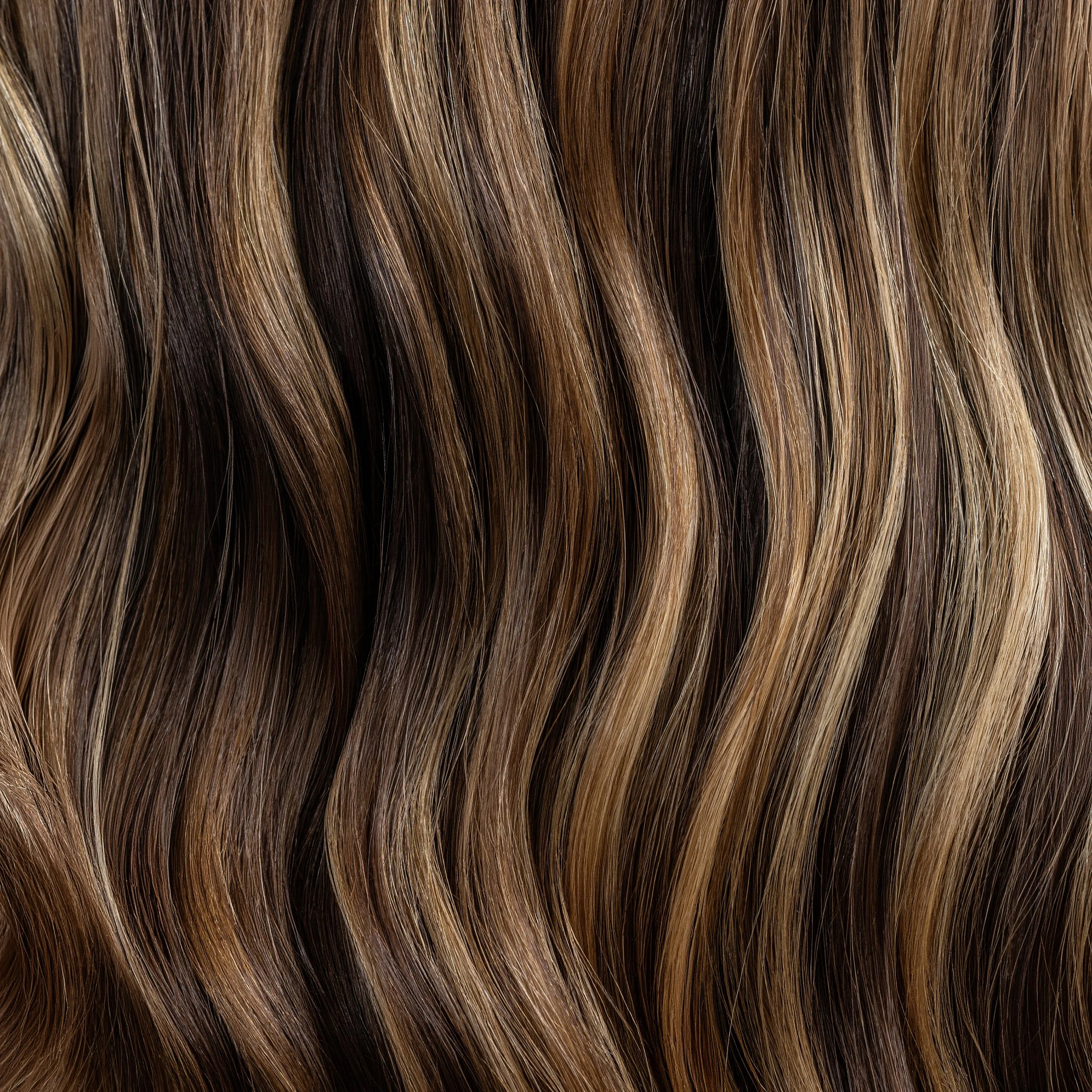 Close-up of dimensional highlighted hair showing warm tones, texture and shine.
