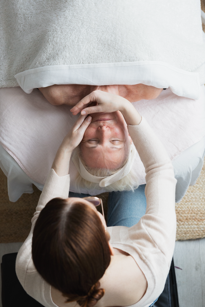 Overhead view of a woman receiving a slow facial massage during a relaxing wellness treatment.