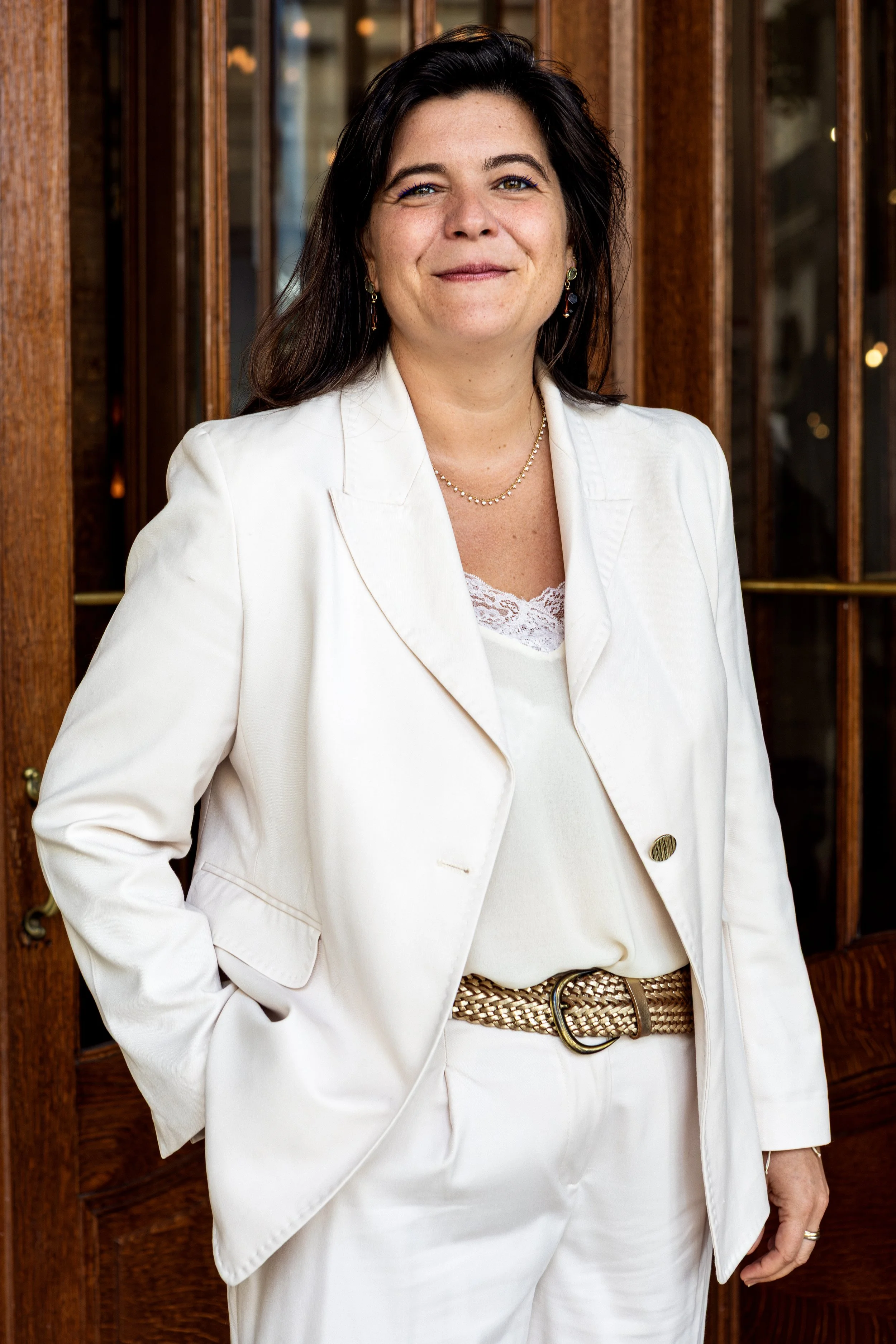 Professional portrait of a woman in a white suit photographed at Hôtel Regina Paris.