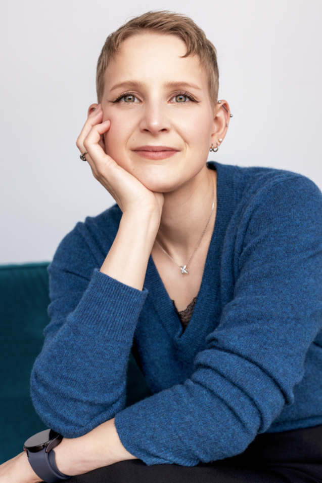 Relaxed personal branding portrait of a woman with short hair wearing a blue sweater.