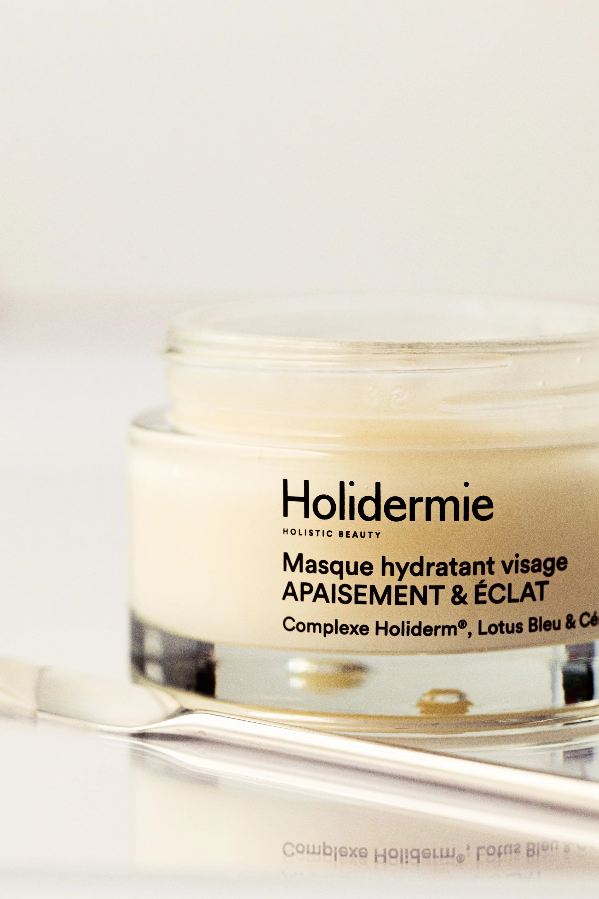 Holidermie hydrating face mask jar photographed in a soft cream-toned minimalist skincare composition.