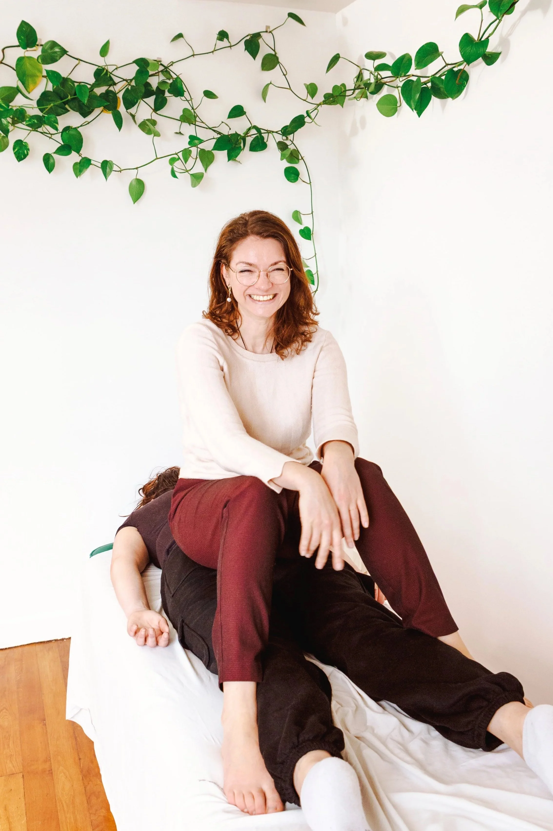 Relaxed portrait of a wellness therapist during a bodywork session in a bright interior.