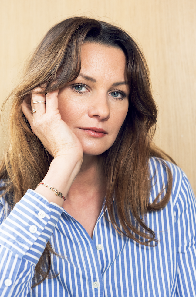 Natural portrait of a woman in a blue striped shirt, photographed in soft light in Paris.
