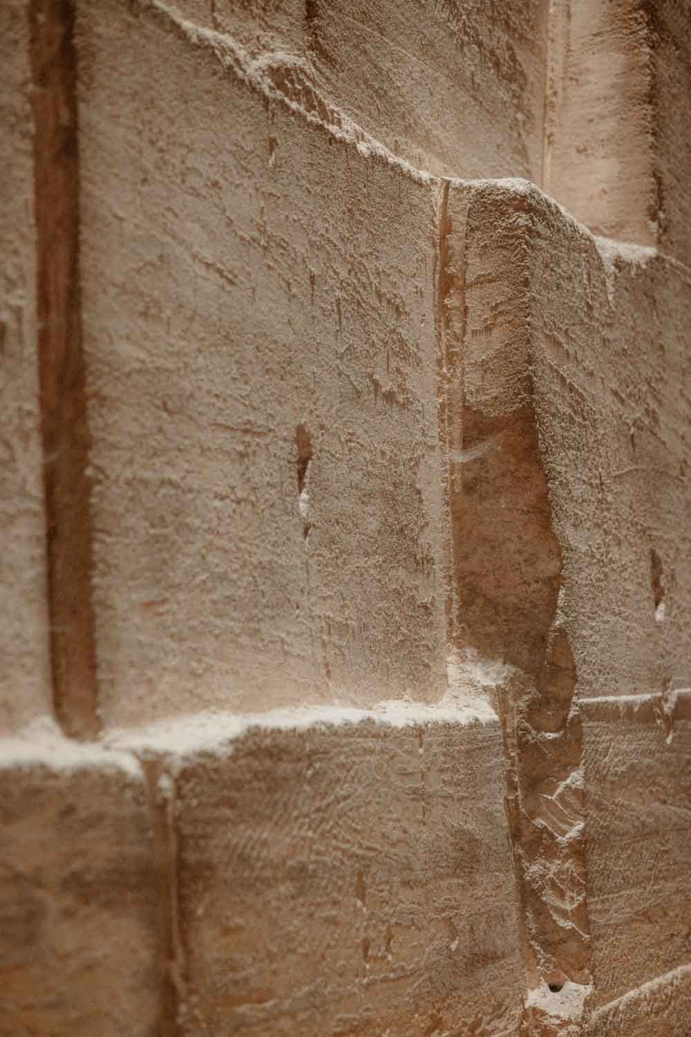 Zoom sur une surface en briques de terre cuite avec de la poussière et de la saleté accumulées dans les joints et les fissures.