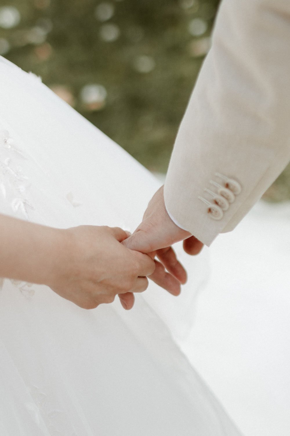 Deux personnes tenant leurs mains, symbolisant un mariage ou une union, avec un fond flou.