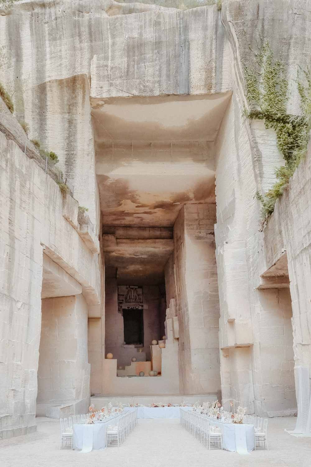 Ancienne structure en pierre avec un espace intérieur ouvert, décoré avec des tables et des chaises pour un événement.