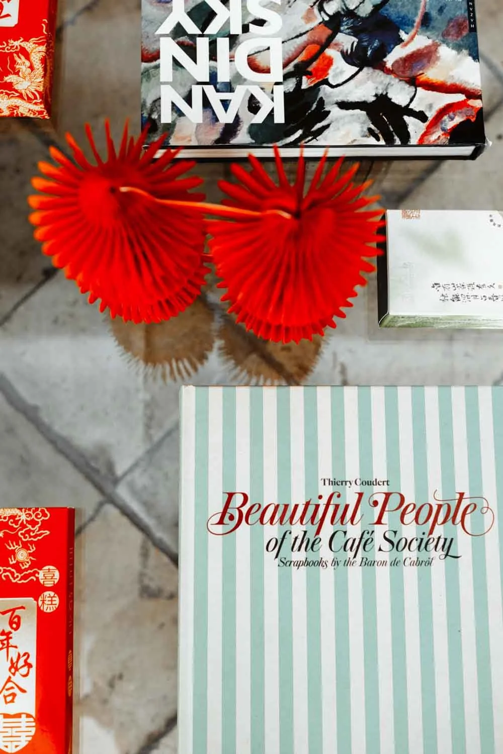 Deux fleurs rouges en plastique disposées sur une table en pierre.