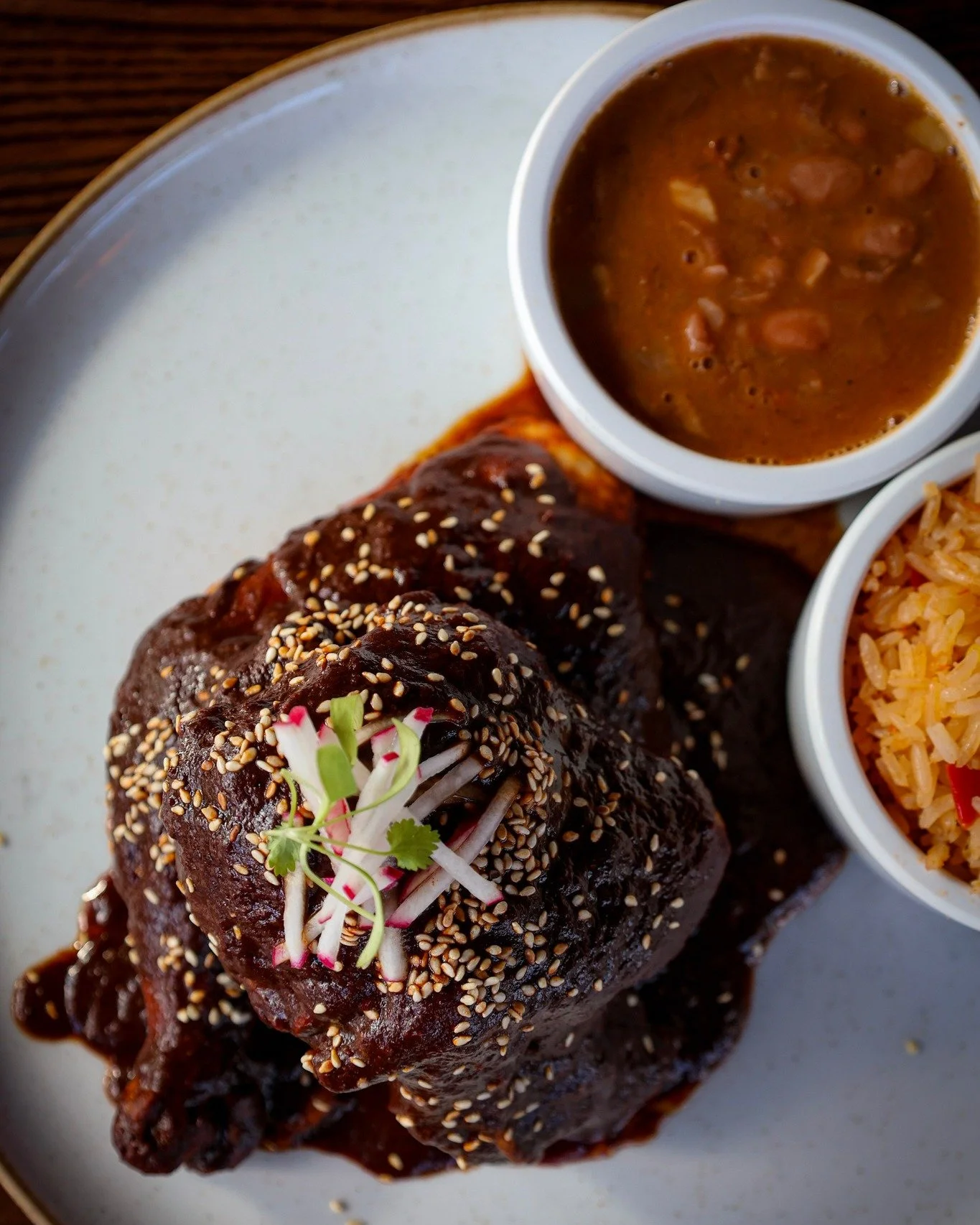 Our Pollo con Mole is pure comfort &mdash; tender half-chicken slow-cooked in our family&rsquo;s traditional mole, rich with chiles, spices, and a touch of sweetness. Served with Mexican rice, charro beans, and toasted sesame seeds.
A taste of home, 