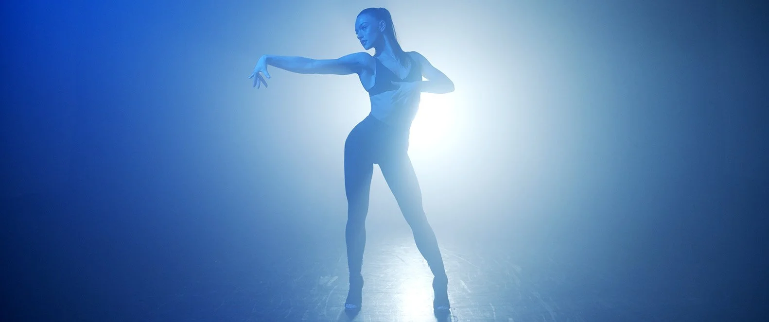 Dancer in silhouette against bright blue light by Nexus
