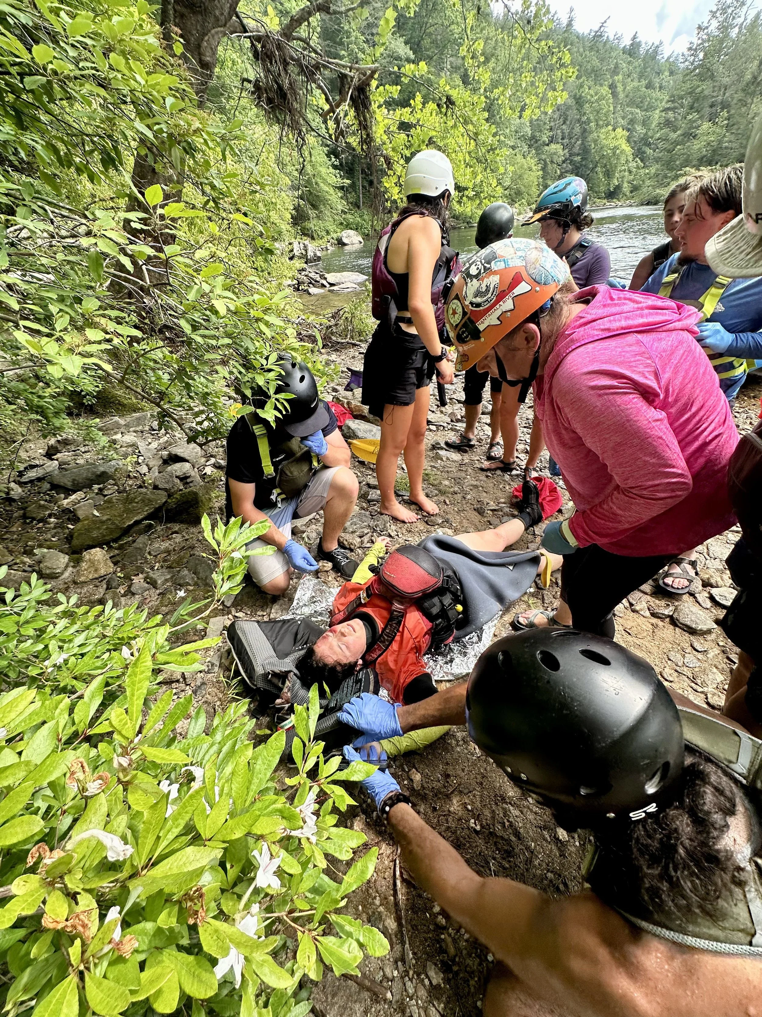 Emergency responders caring for an unconscious kayaker on the banks of the Chattooga River. Moving an injured patient with an improvised litter. Wilderness Advanced First Aid Training in the Southeast