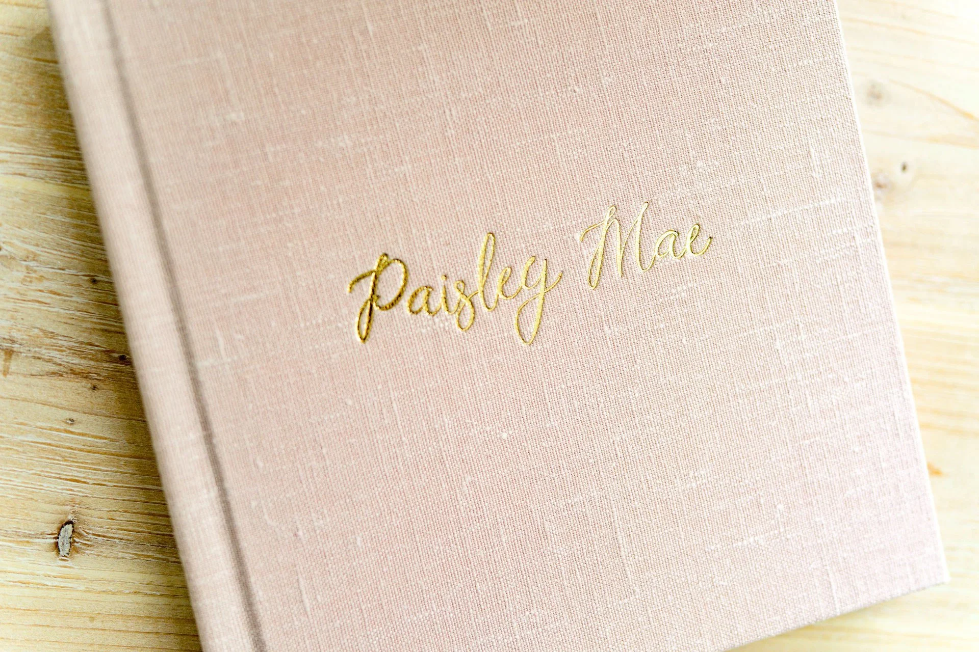 Linen heirloom photo album with a personalized gold name on the cover.