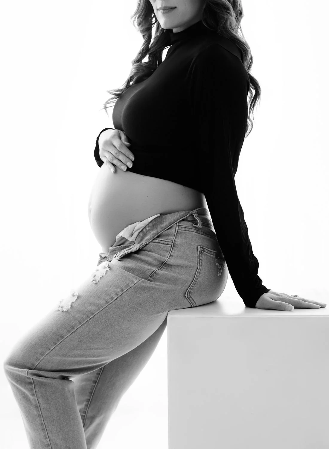 everyday editorial style maternity image in black and white creatively cropped to accentuate baby bump
