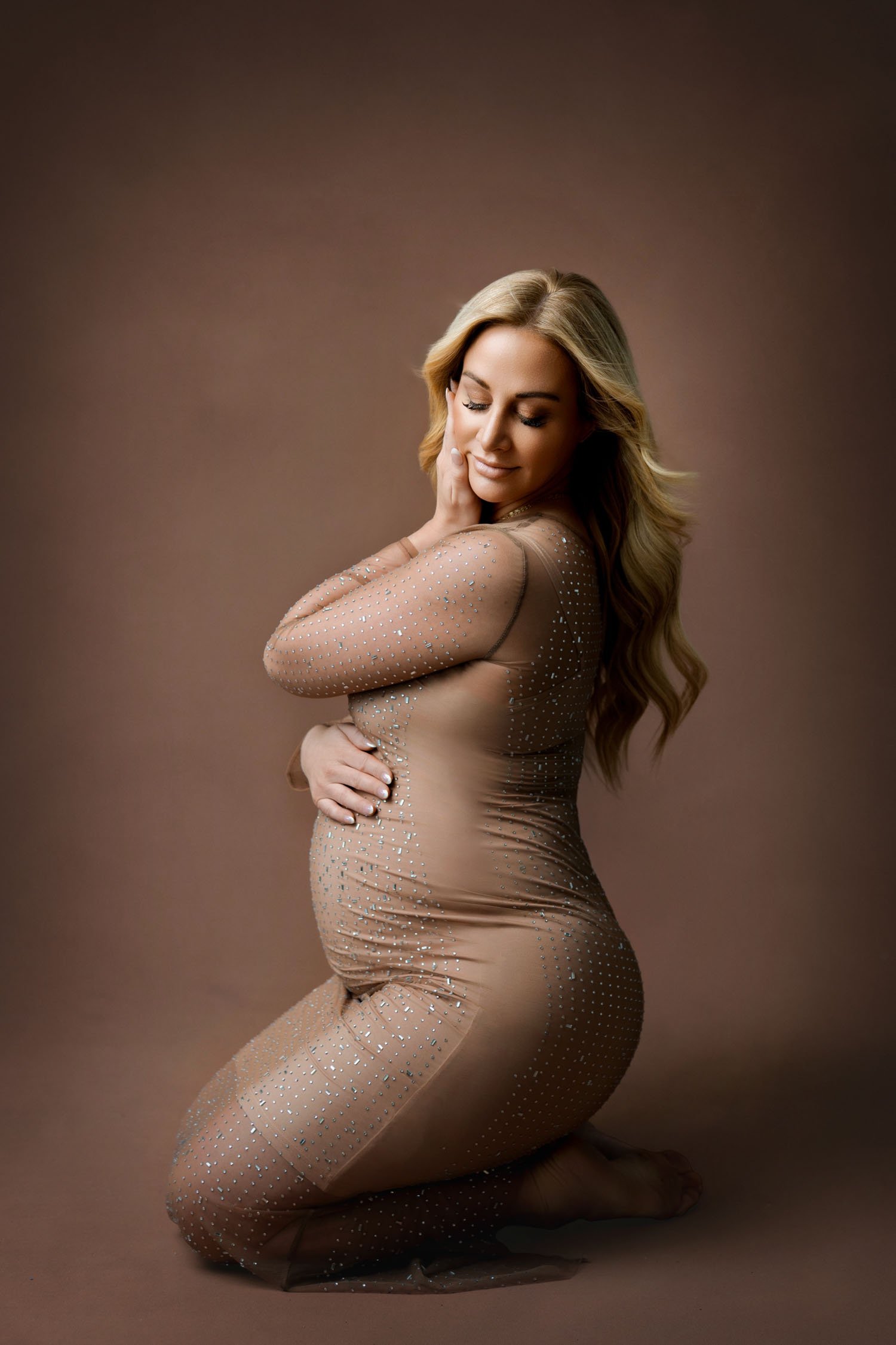Pregnant woman posing in a fitted embellished maternity gown during a St. Louis maternity photography session.