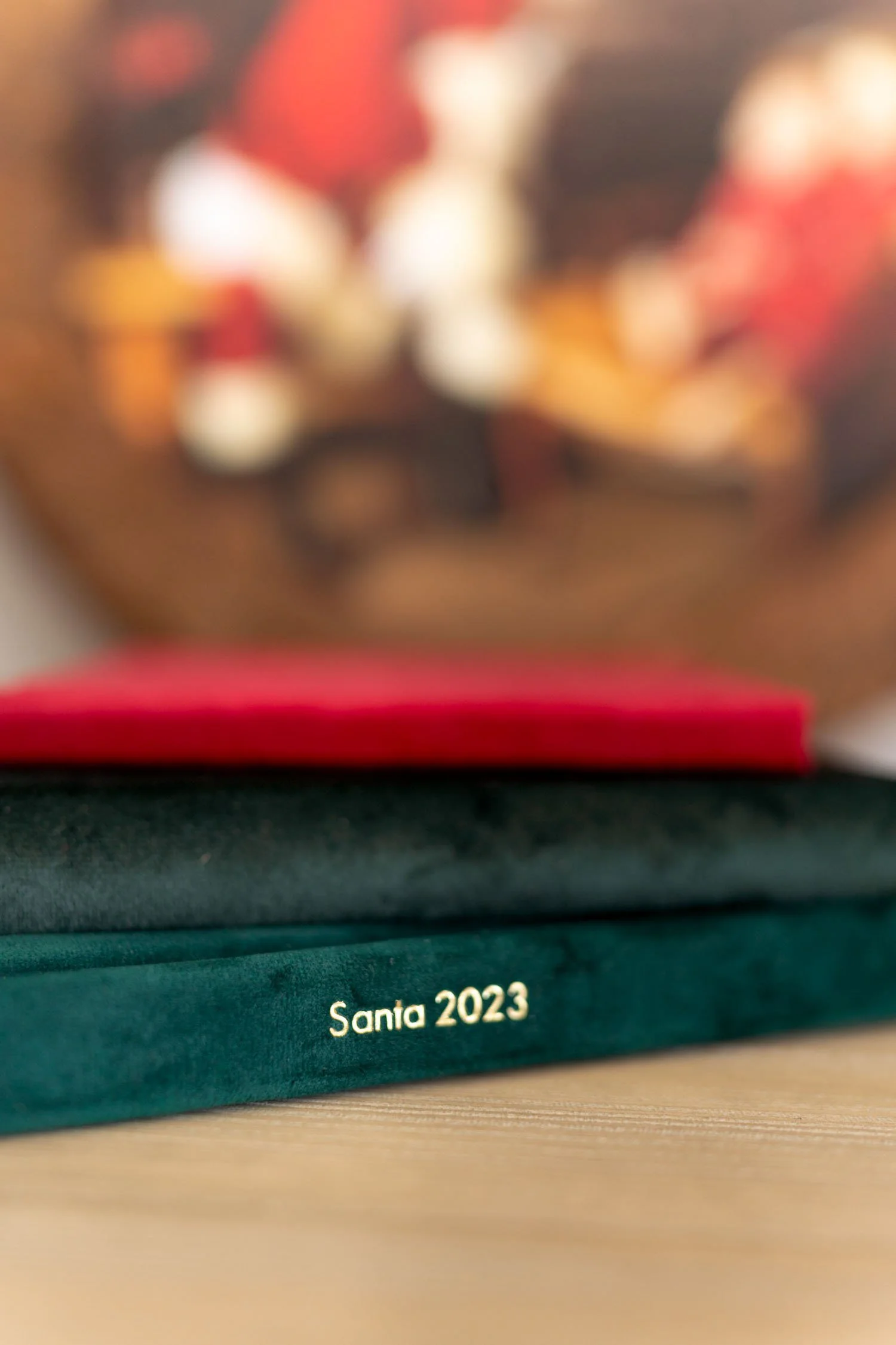 Red and green personalized Santa photo albums stacked together.