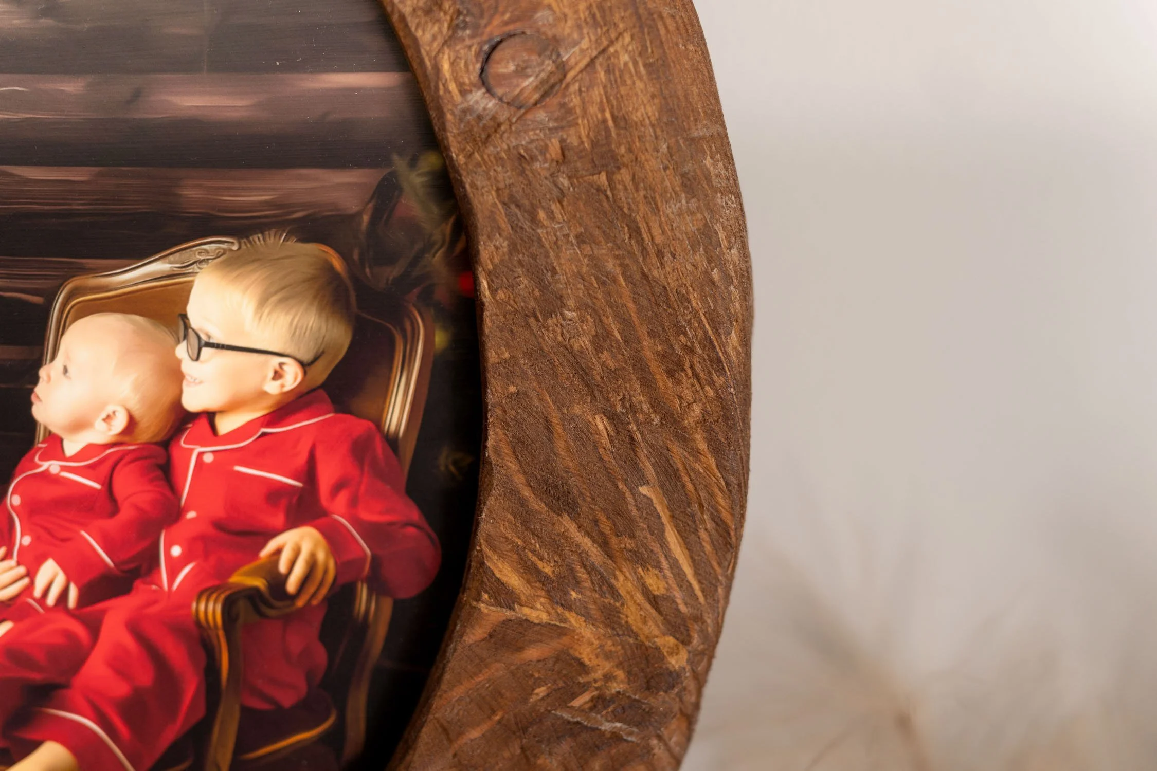 1. Close-up detail of a round wooden Santa portrait artwork with a printed holiday photograph.