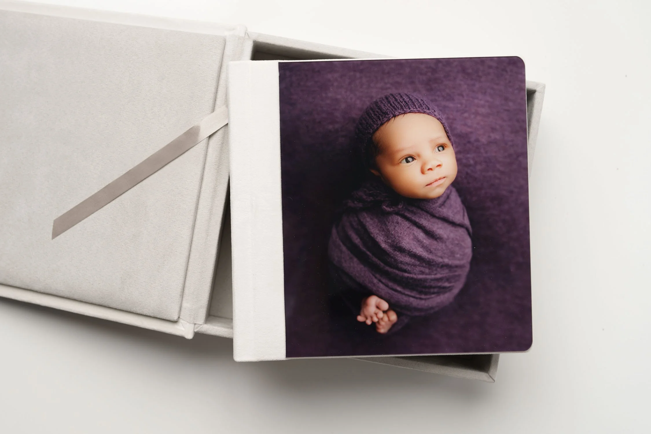 Newborn portrait acrylic album with a baby photograph printed on the cover.