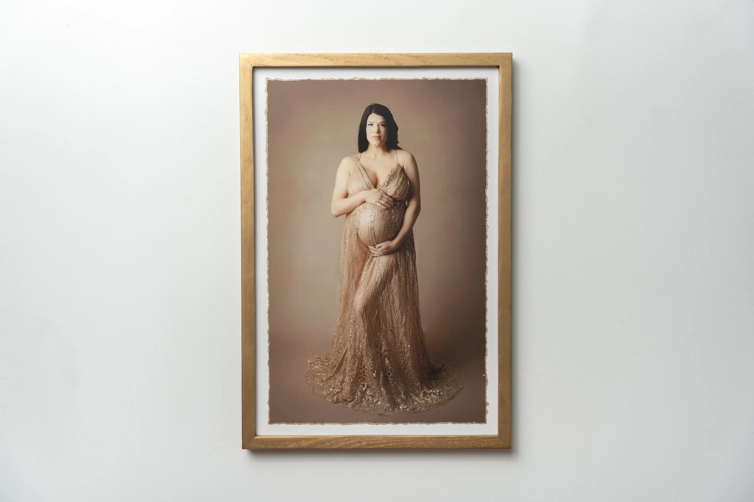 Framed portrait of a pregnant woman in an elegant maternity gown displayed as wall art.
