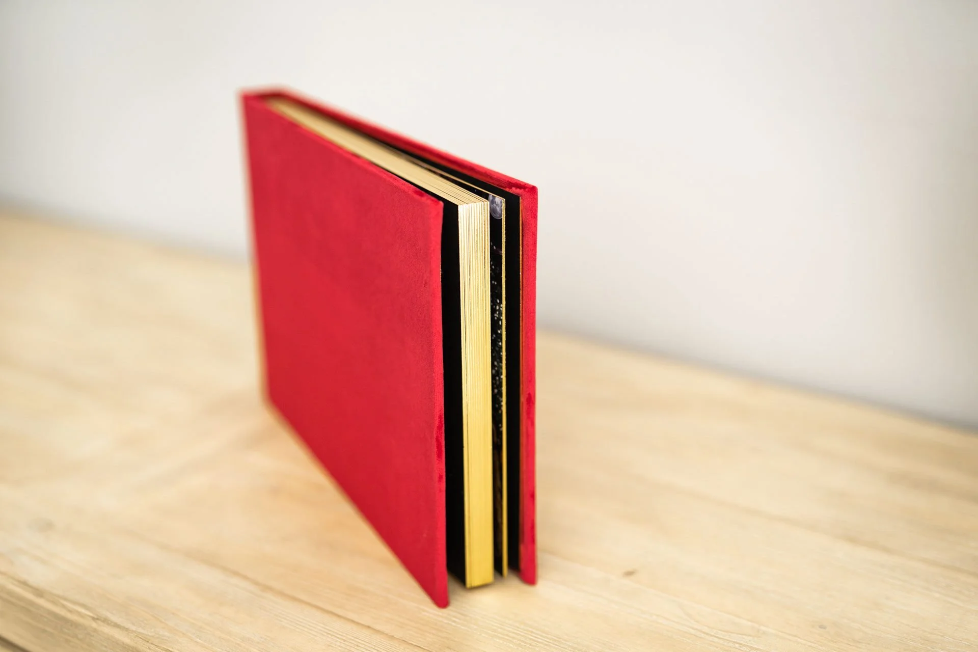 Red heirloom Santa photo album with personalized gold gilding on the cover.