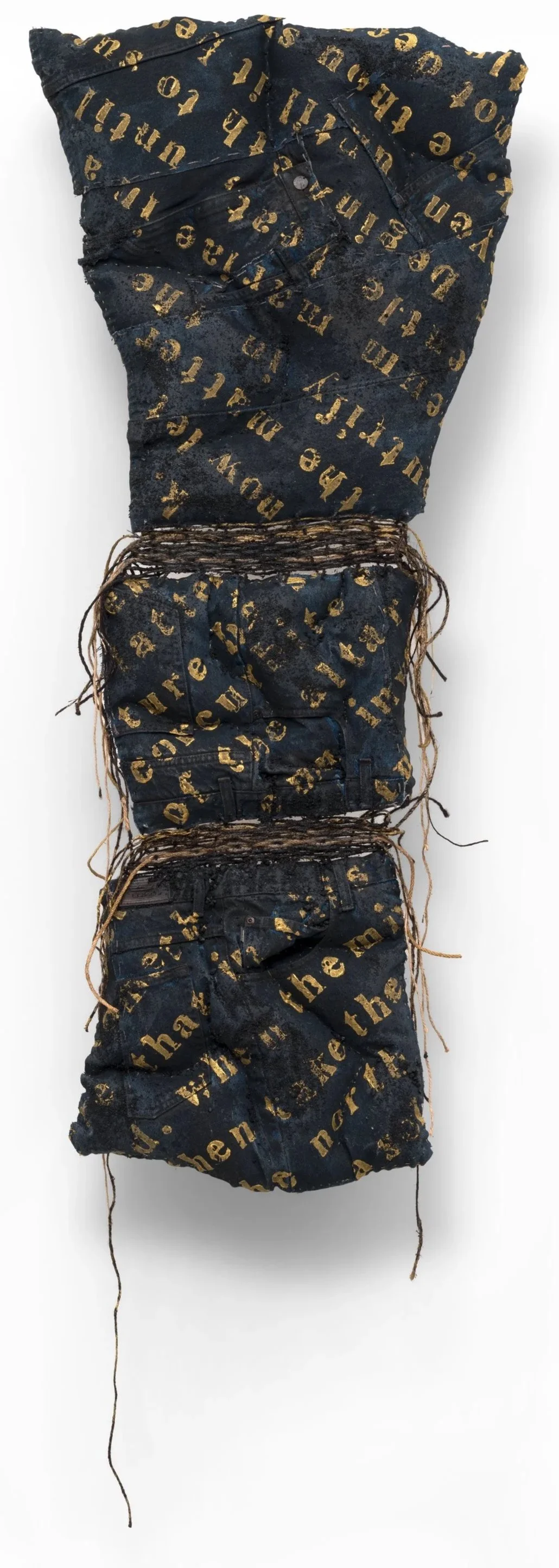 Joy Ray|proven through longing|2026|Thrift store denim, twine, fabric, paint, sand, gravel; text from The Red Book by Carl Jung|52x23x4 Inches