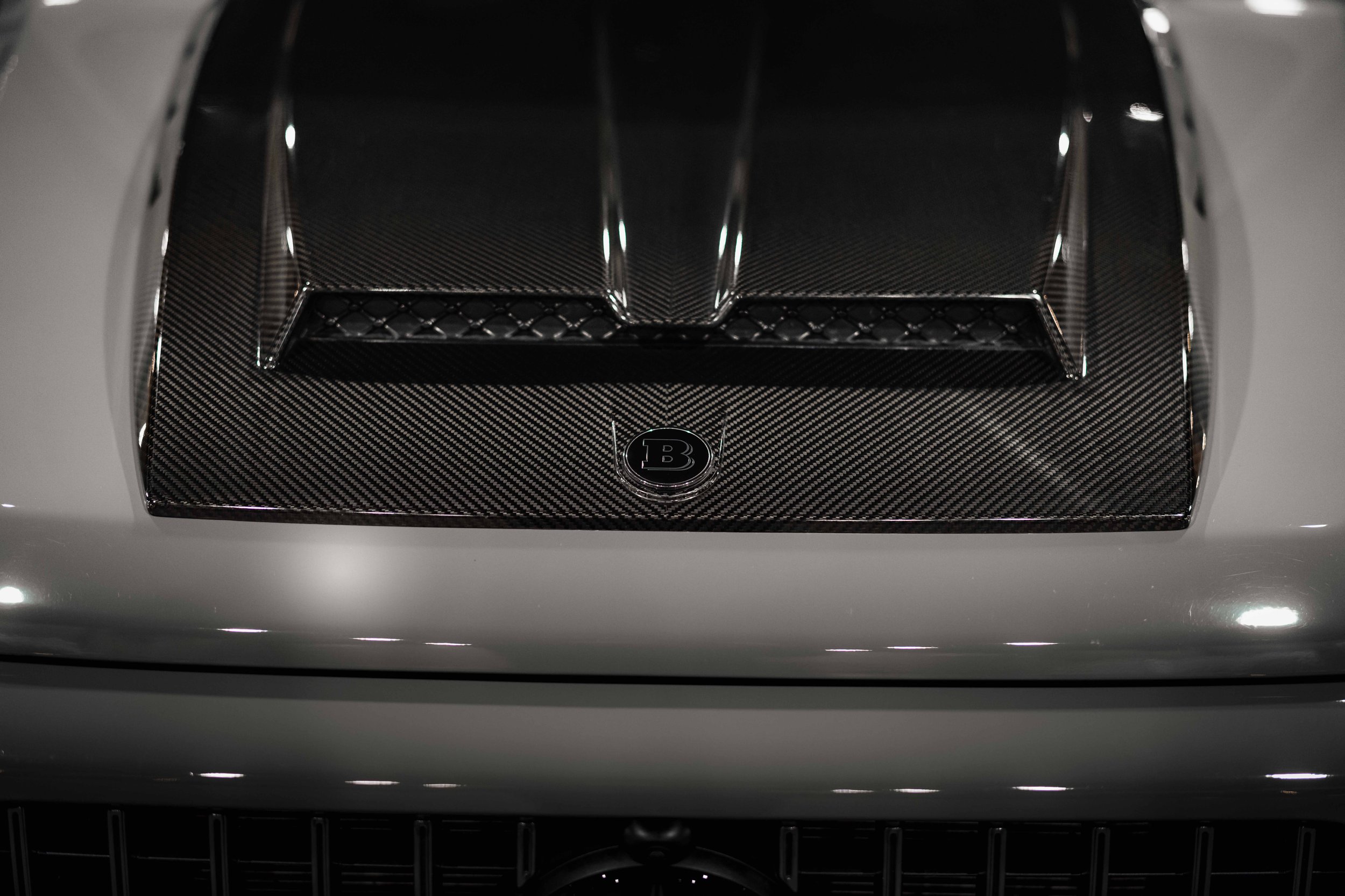 Carbon Fiber Hood Scoop
Detail of the carbon fiber Brabus-style hood scoop on the Mercedes G63, enhancing aerodynamic performance and a bold, sporty aesthetic.