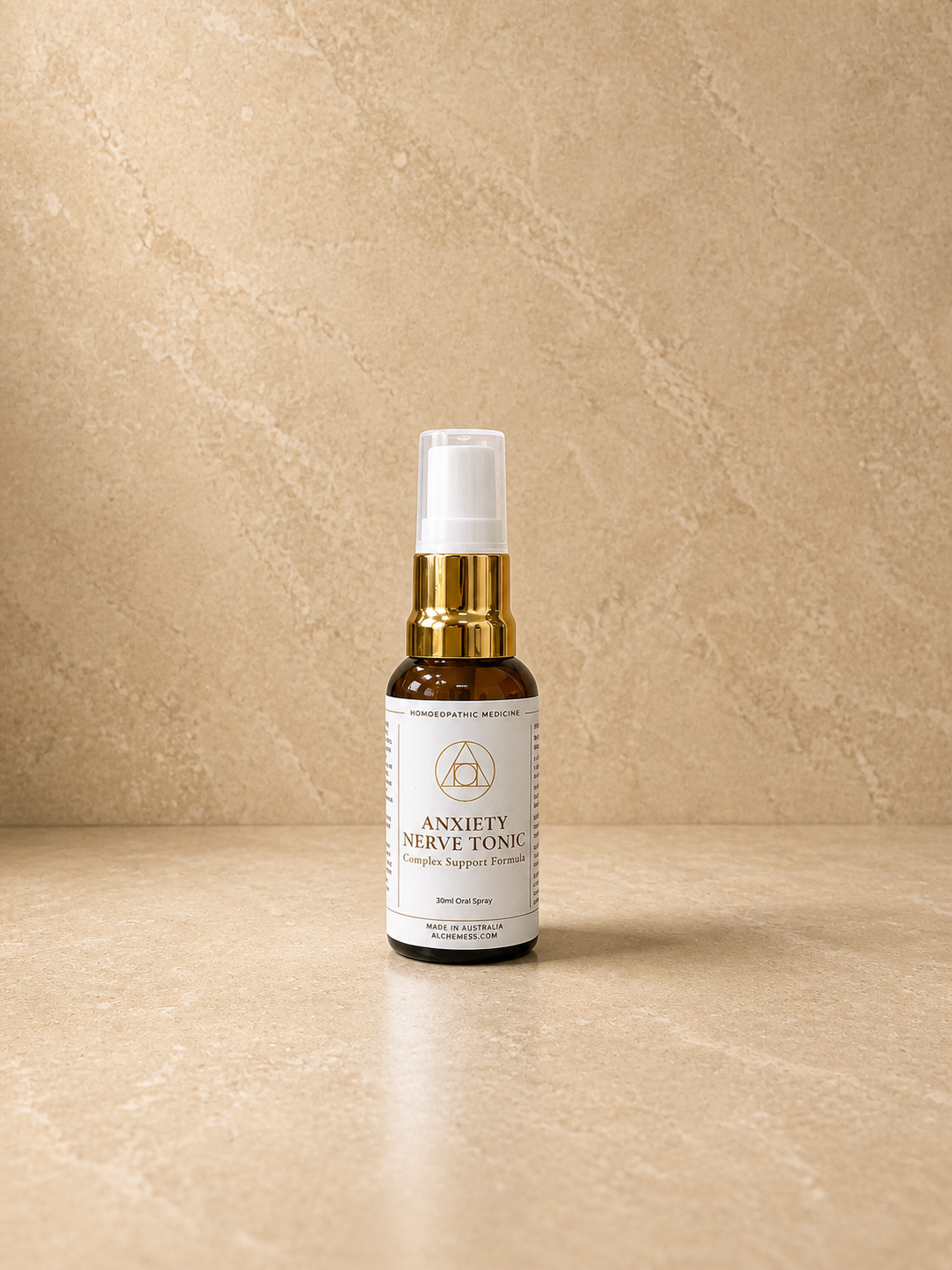 A small amber glass dropper bottle labeled 'Alchem{ess} System Support Essence Anxiety + Nerve Tonic' with a black dropper cap, placed against a white background.
