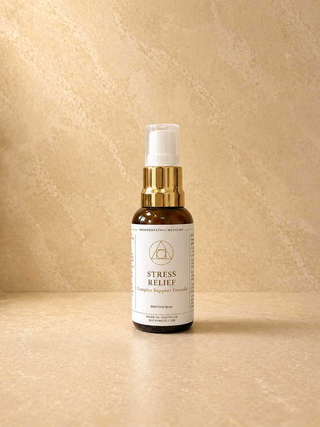 Amber glass spray bottle labeled 'Alchem{ess} System Support Essence Stress Relief' with white label and black spray nozzle against a white background.