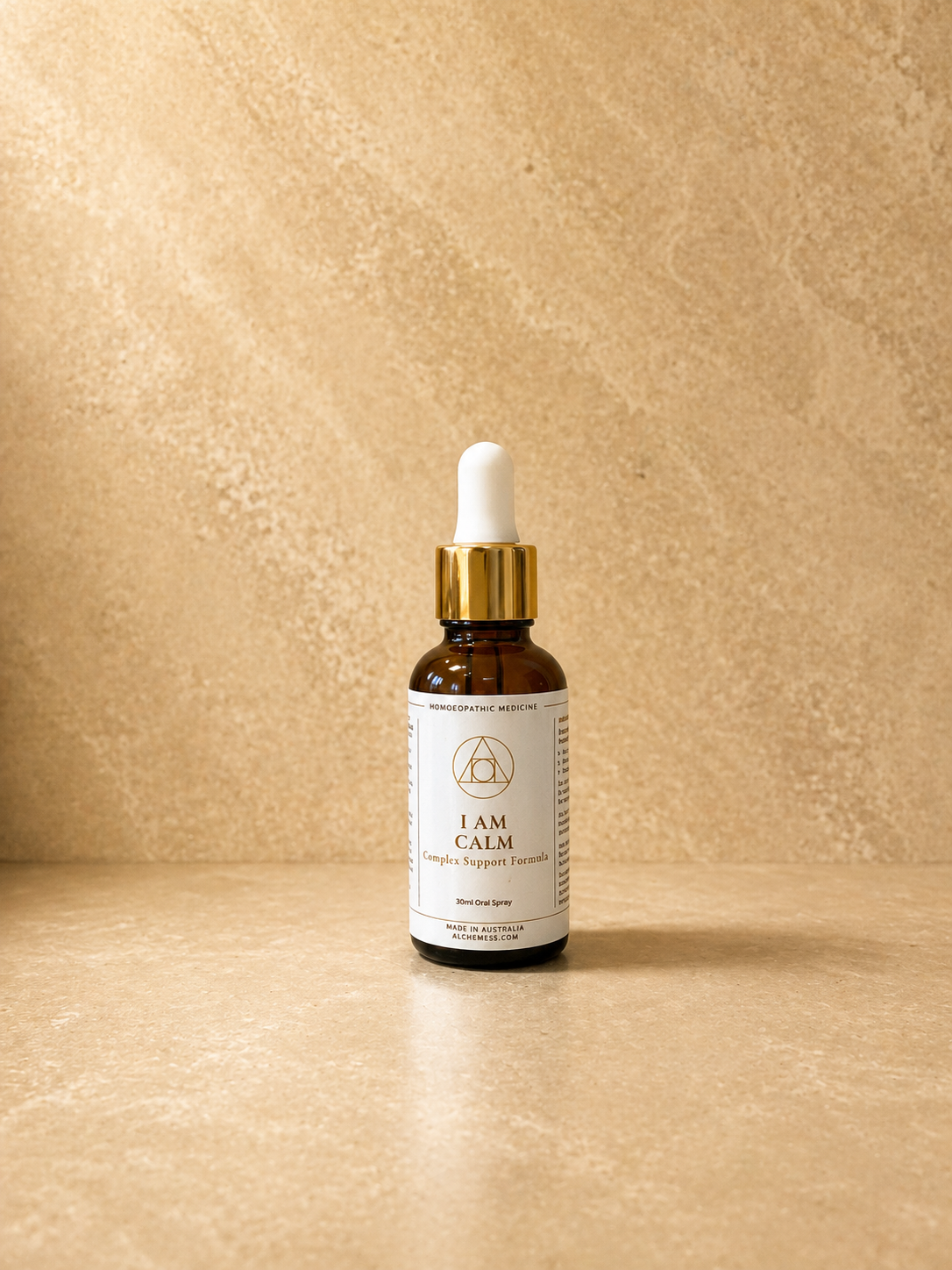 A small brown glass bottle with a black dropper cap labeled "Alchemy System Support Essence - I AM Calm" against a plain white background.