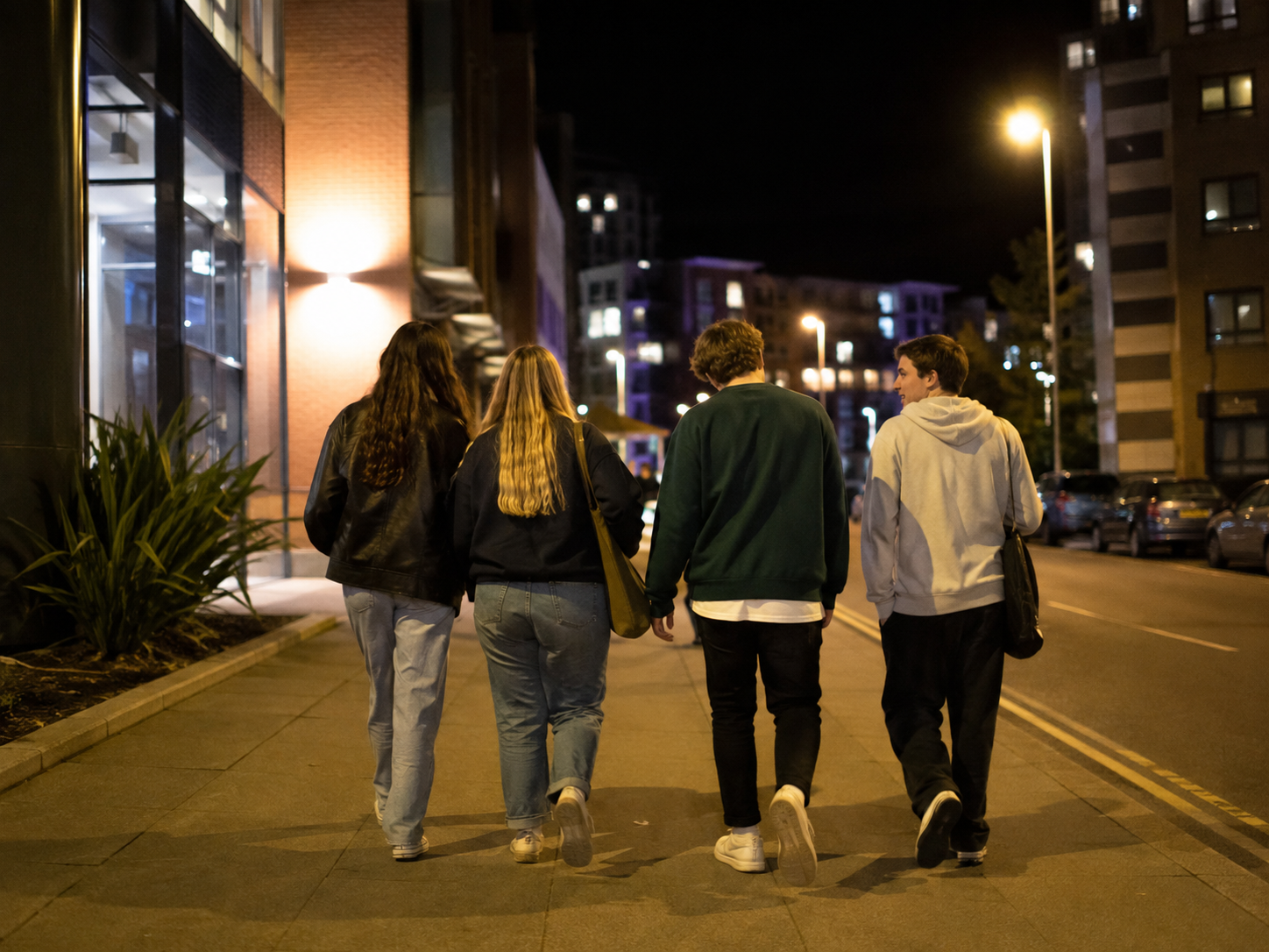 Group of students walking home together at night on a well-lit street, representing safer journeys, friendship and looking out for each other during Freshers’ Week.