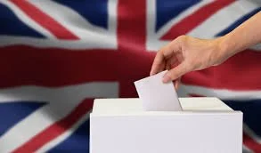 Voter placing a ballot paper into a ballot box with the UK flag in the background, representing democratic participation in local elections.