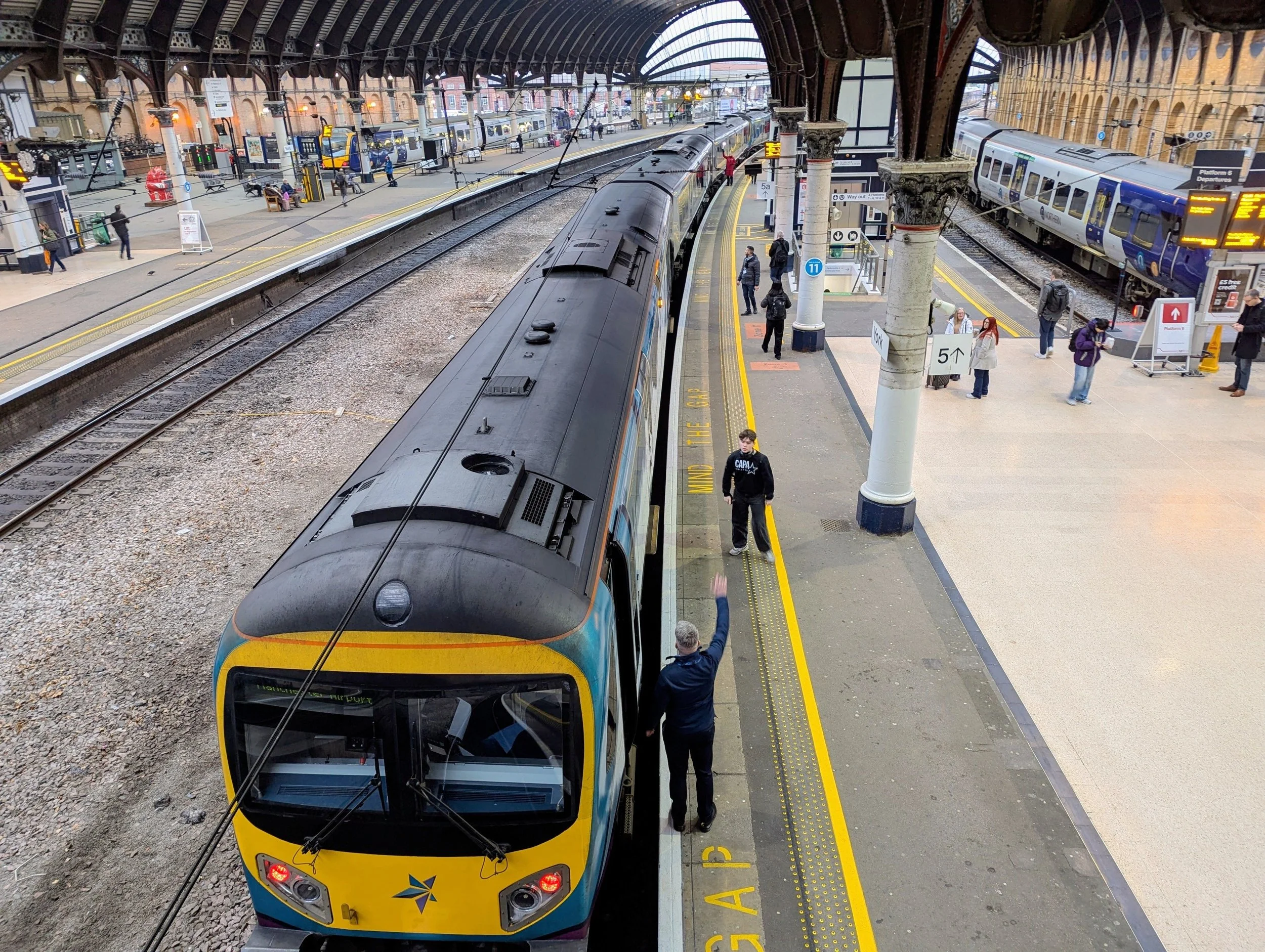 A train at a busy UK railway station platform, supporting imabi’s article on the Safer Railway Scheme, passenger safety, safeguarding, reporting and safer rail journeys.