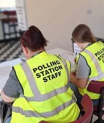 UK polling station staff preparing to support voters on election day, helping manage the voting process and ensure polling stations run smoothly and guide people through the voting process safely and confidently.