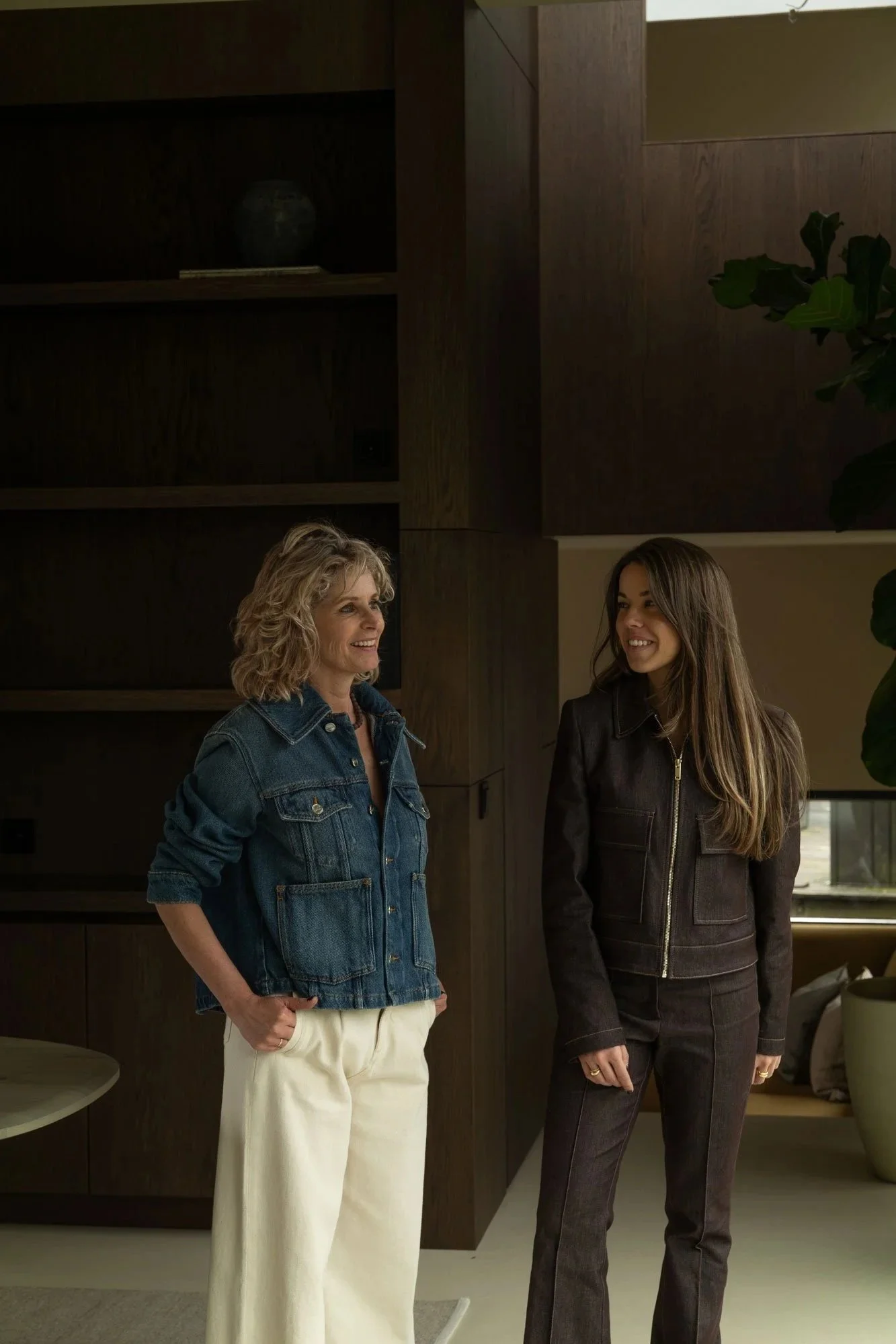 Interieurontwerper Romy Engelhard van Studio Engelhard in gesprek bij een high-end houten maatwerkkast, passend binnen een tijdloos interieurontwerp met een sfeer van ingetogen luxe.