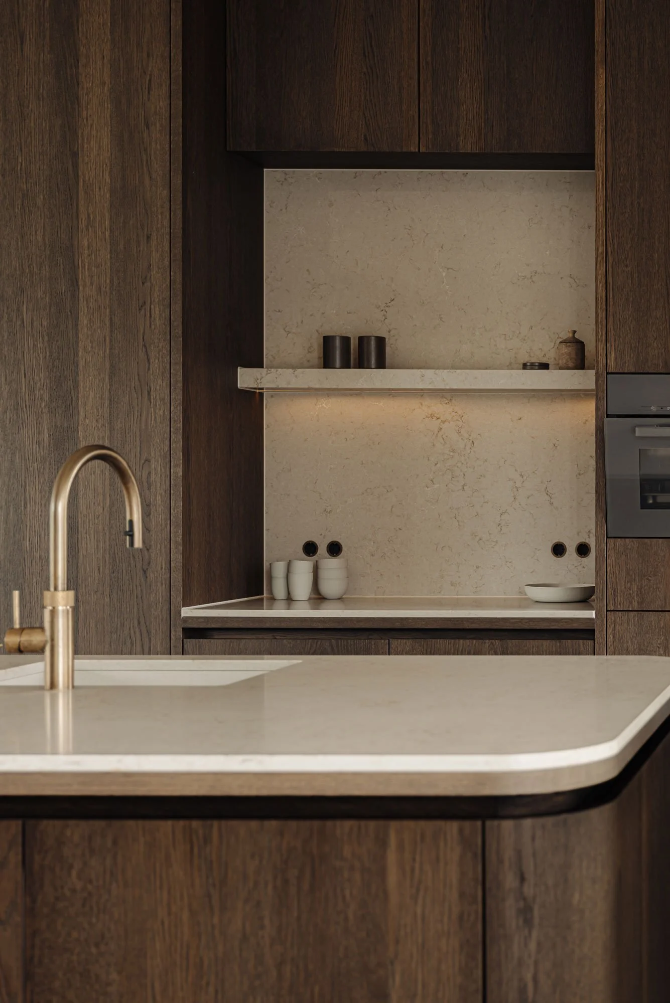High-end koffiecorner met led-verlichting en een marmerlook achterwand in een luxe keukenontwerp, gerealiseerd door Studio Engelhard uit Amsterdam.
