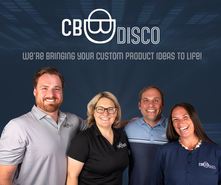 Four smiling team members wearing branded polo shirts and a necklace, standing together in front of a digital blue background with the company's logo and slogan for CB Disco, a business involved in custom product ideas.