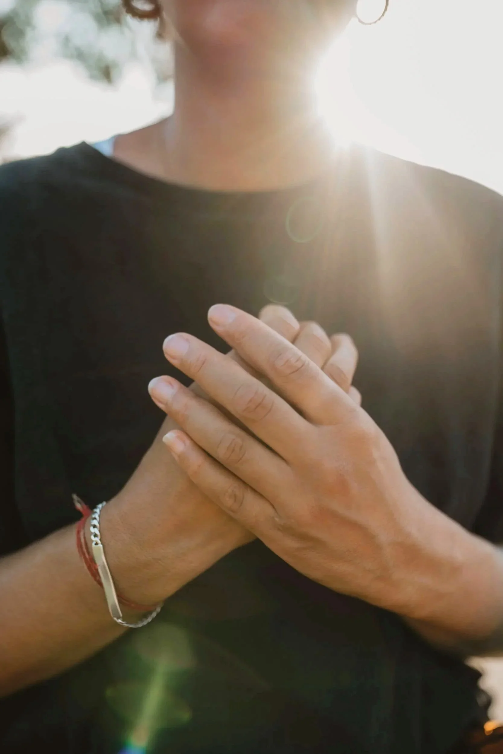 Hände ruhen vor dem Brustraum als Ausdruck von Selbstwahrnehmung, Präsenz und Atemarbeit