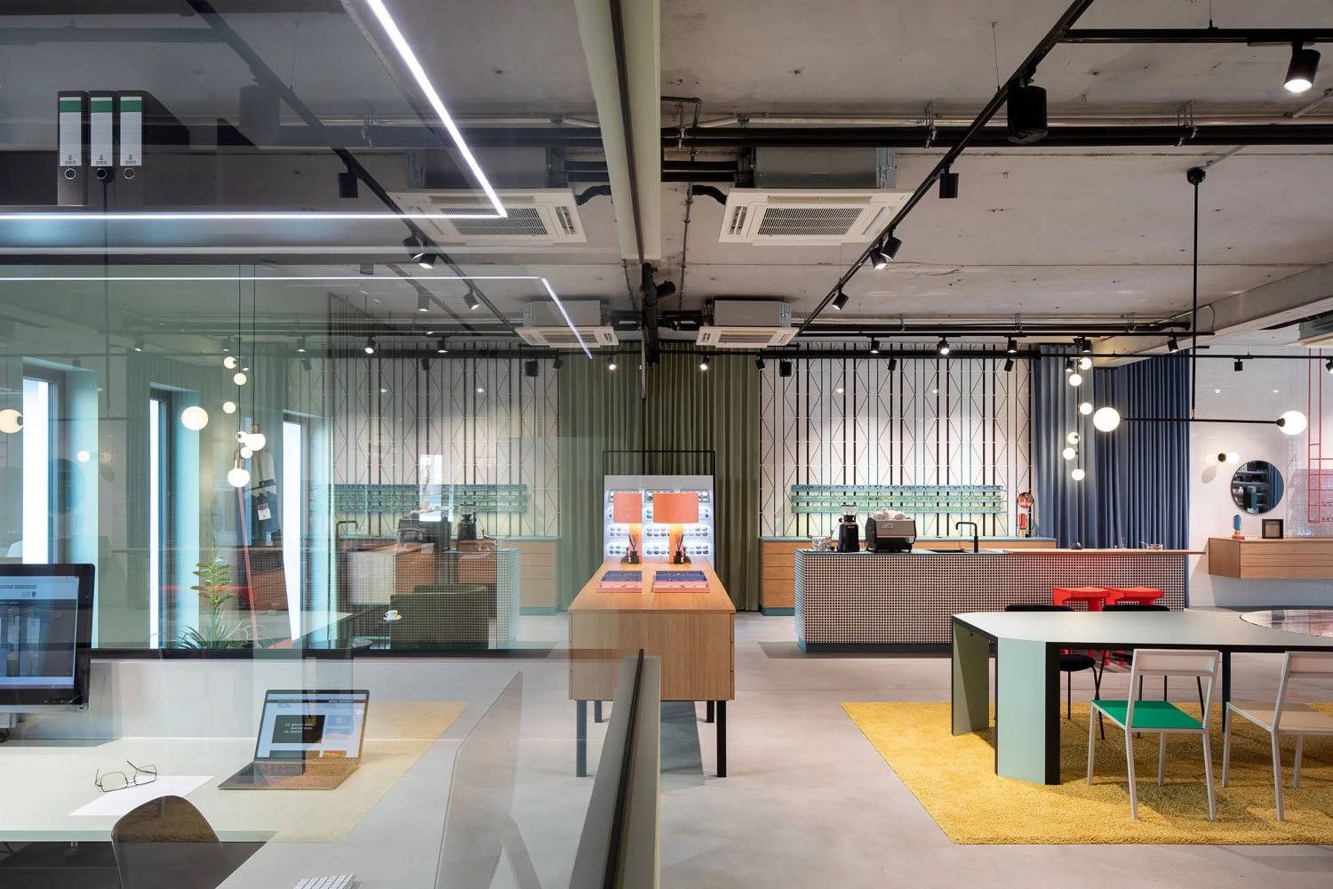 Innenraumfotografie des von Stephanie Thatenhorst gestalteten Optikergeschäfts mit großer Glasfläche zum Bürobereich sowie Spiegelungen und Durchblicken auf die Verkaufsfläche