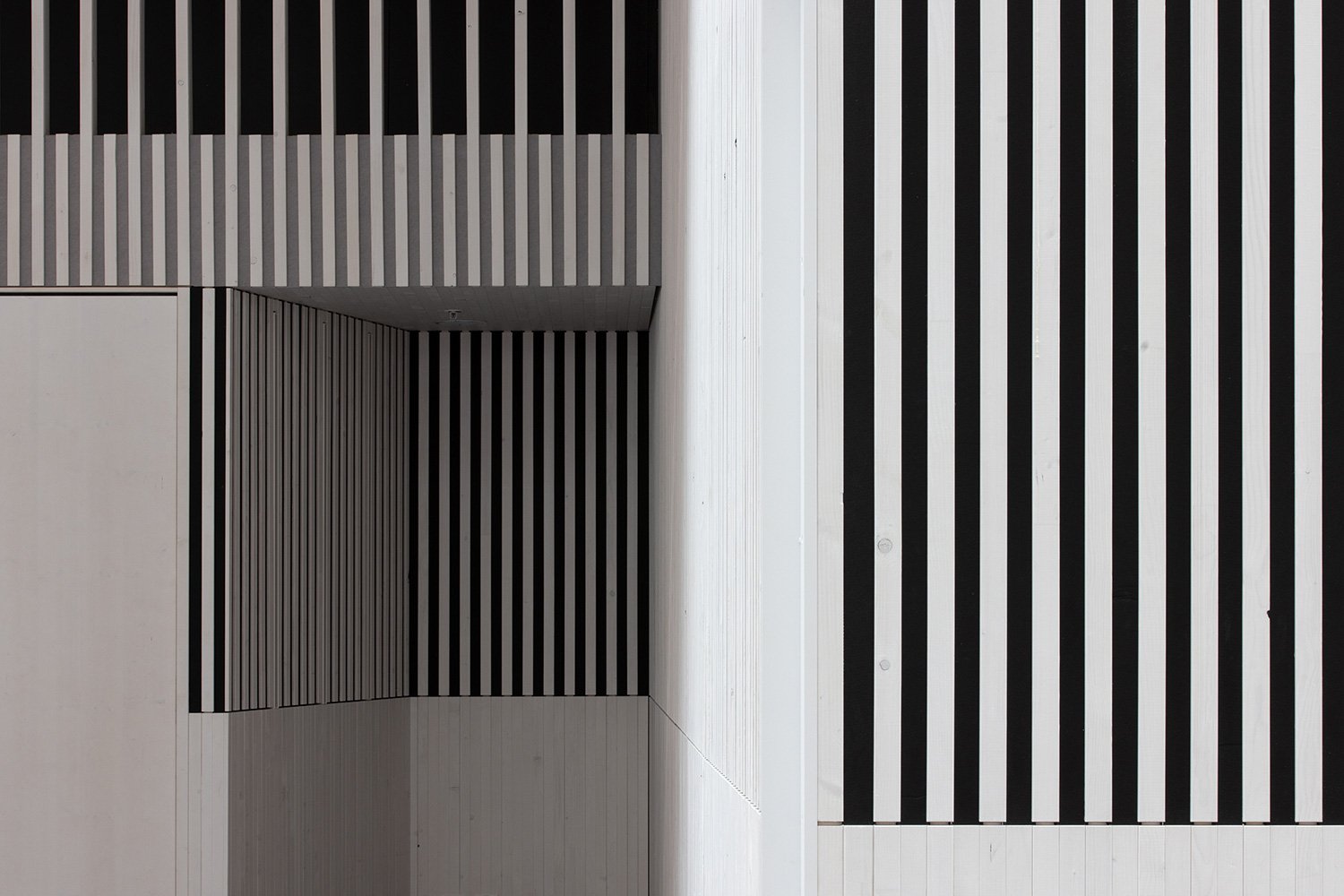 Detailansicht der Holzlamellenwand im Foyer der SGKB Halle St. Gallen mit grafischer Linienführung und Licht-Schatten-Wirkung.
