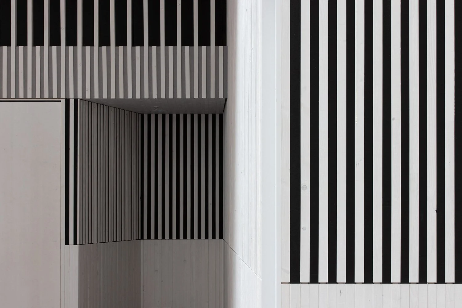 Detailansicht der Holzlamellenwand im Foyer der SGKB Halle St. Gallen mit grafischer Linienführung und Licht-Schatten-Wirkung.
