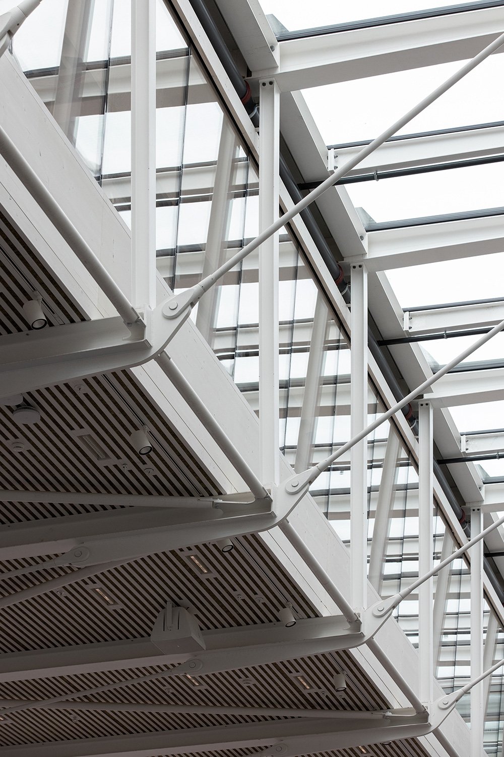 Architekturfotografie eines Stahlbau-Details im Foyer der SGKB Halle St. Gallen mit filigraner Tragkonstruktion und Glasdach.
