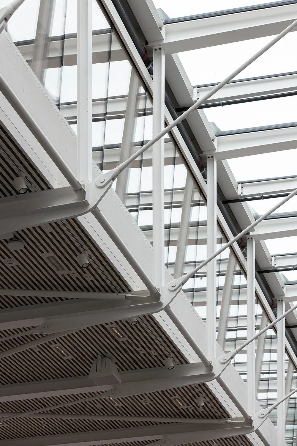 Architekturfotografie eines Stahlbau-Details im Foyer der SGKB Halle St. Gallen mit filigraner Tragkonstruktion und Glasdach.
